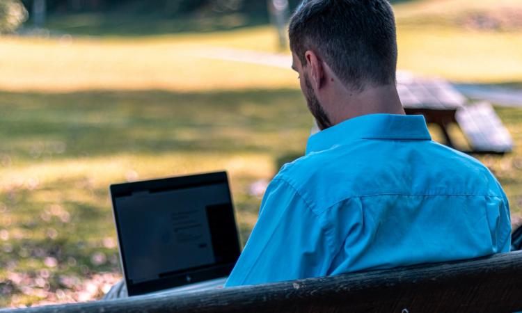student sitter med laptop i himlabacken